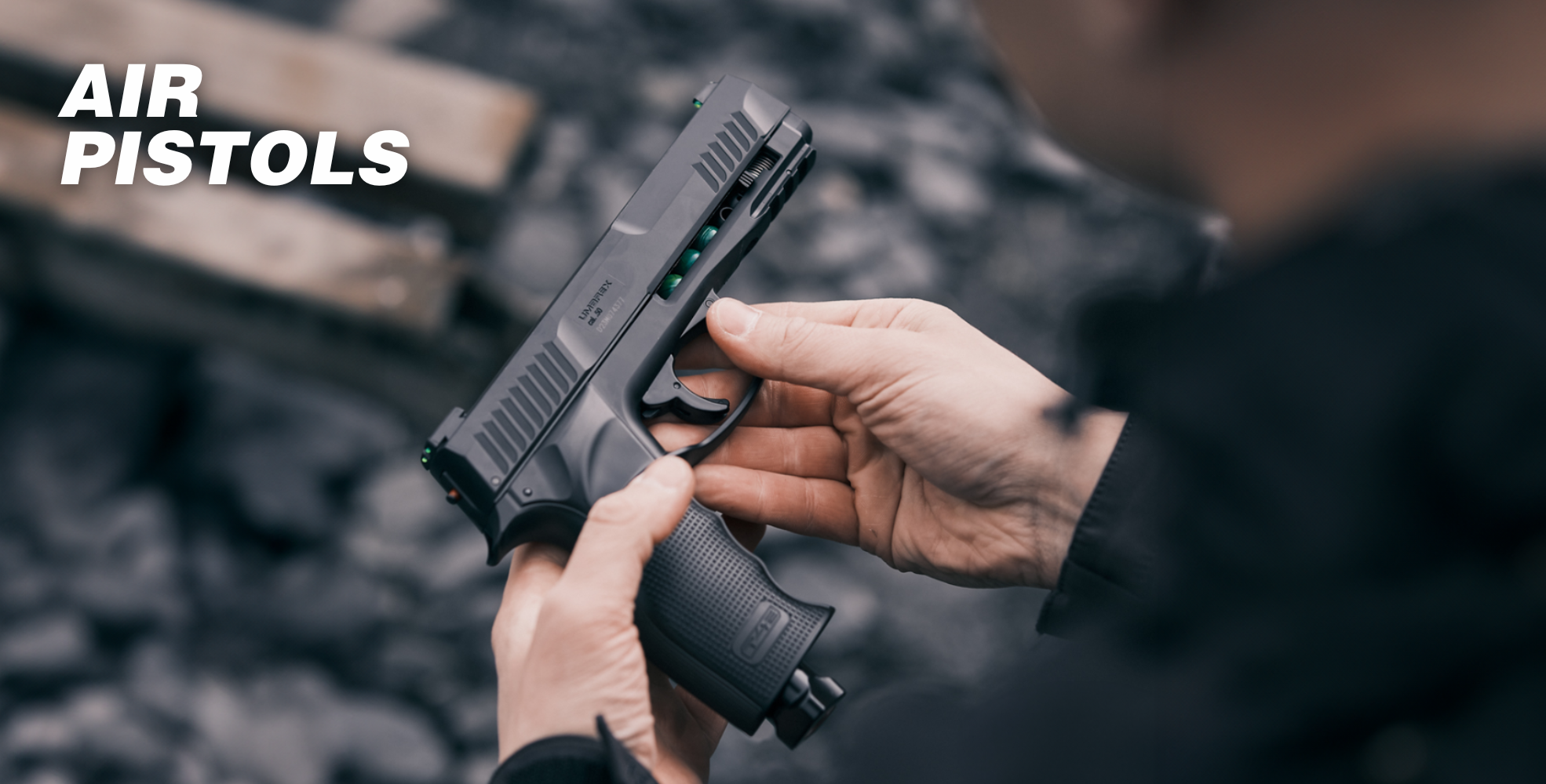 Person holding a black air pistol outdoors, with the text "AIR PISTOLS" in the corner.