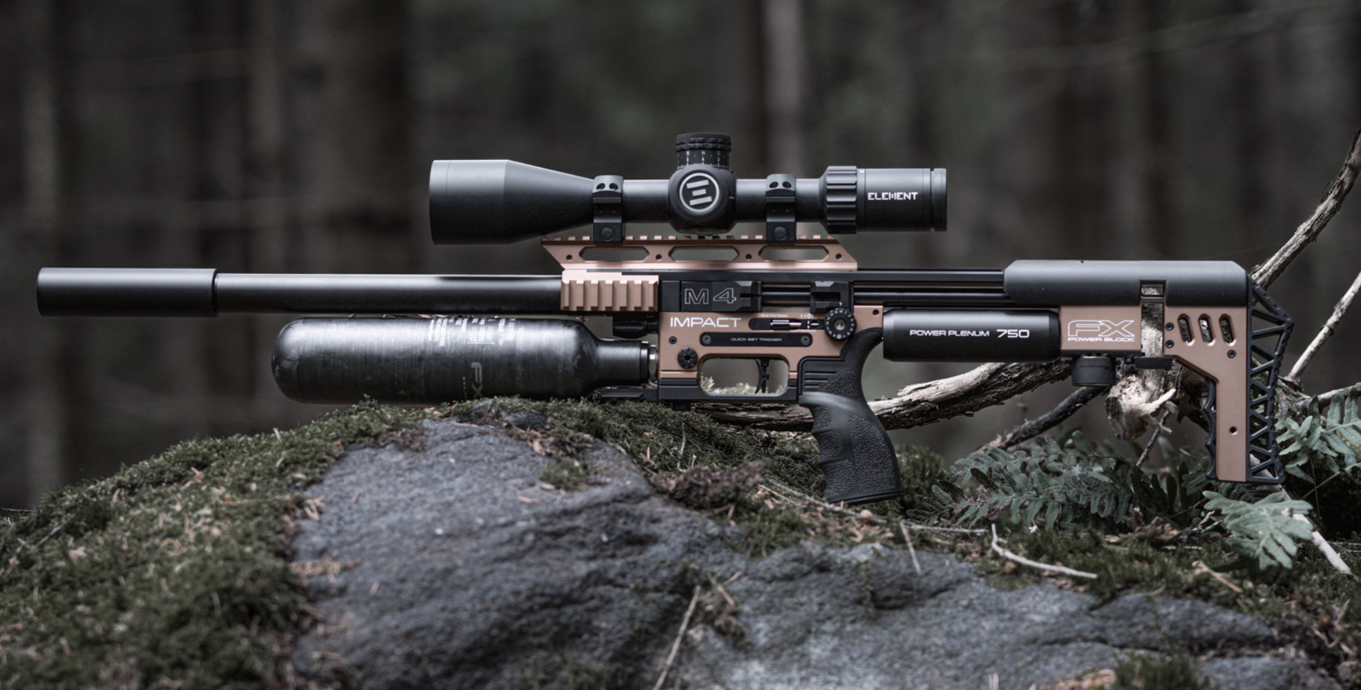 A modern air rifle with a large scope and black silencer rests on a mossy rock in a forest, surrounded by branches and greenery.