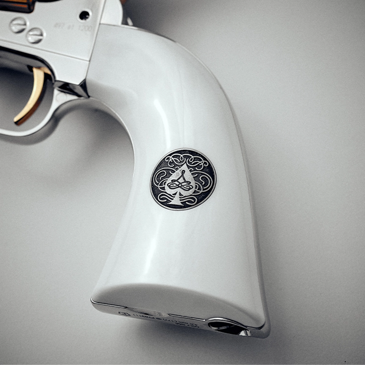 Colt SAA 'Smoke Wagon' CO2 Pistol 7 A close-up of the Colt SAA CO2 Smoke Wagon Pistol .177 Pellet, a silver revolver with a white grip and ornate black emblem.